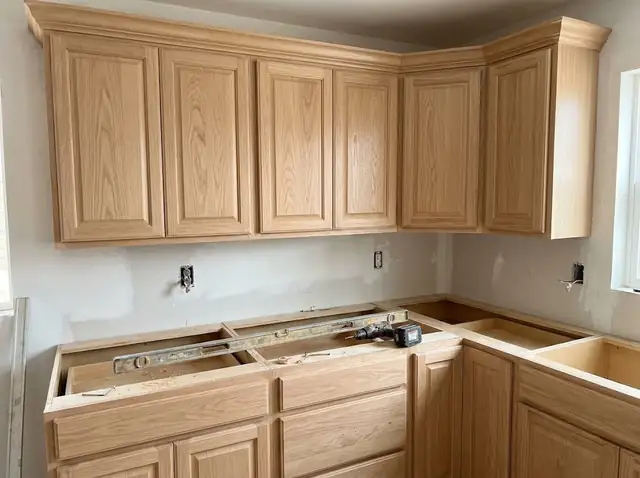 Illustration of newly installed oak kitchen cabinets with a level resting on the base cabinets